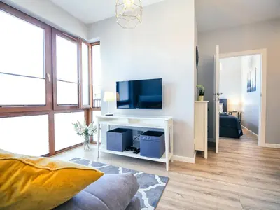 a living room with a tv on a white table at Way2Stay Rakowicka in Kraków