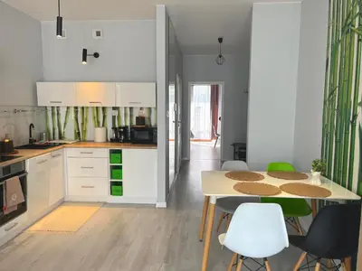 a kitchen with white cabinets and a table and chairs at Way2Stay Rakowicka in Kraków