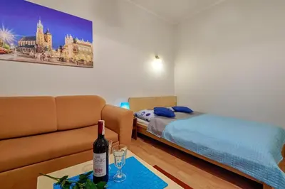 a living room with a couch and a bed at Libro Rooms in Kraków