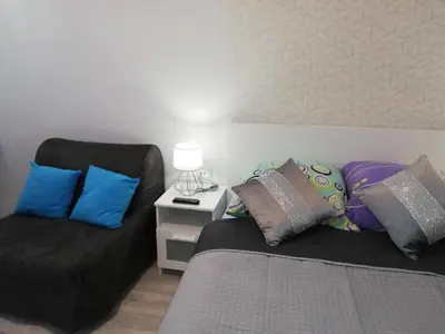 a bedroom with a bed and a couch with pillows at Libro Rooms in Kraków