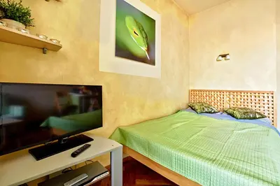 a bedroom with a bed and a flat screen tv at Libro Rooms in Kraków