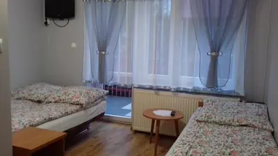 a room with two beds and a window with curtains at Agroturystyka u Basi in Wola Kalinowska