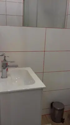 a white bathroom with a sink and a mirror at Agroturystyka u Basi in Wola Kalinowska