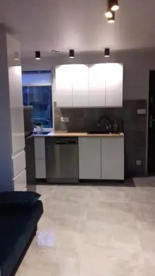 a kitchen with white cabinets and a couch in a room at Agroturystyka u Basi in Wola Kalinowska