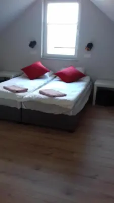 a bedroom with a bed with red pillows and a window at Agroturystyka u Basi in Wola Kalinowska