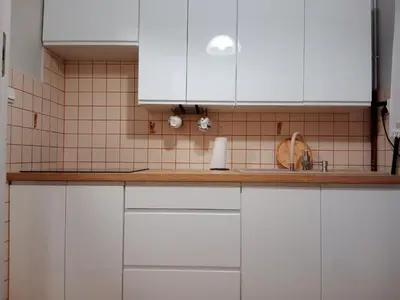 a kitchen with white cabinets and a tiled wall at Agroturystyka u Basi in Wola Kalinowska