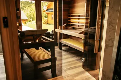 a room with a glass door and a room with wooden furniture at Cztery Pliszki in Zawoja