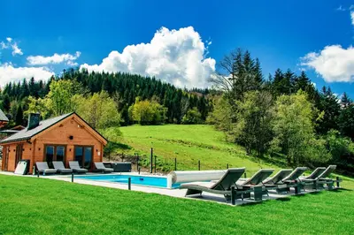 a group of chairs sitting next to a swimming pool at Cztery Pliszki in Zawoja