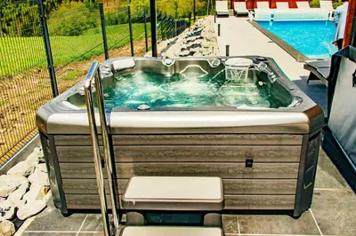 a jacuzzi tub sitting next to a pool at Cztery Pliszki in Zawoja
