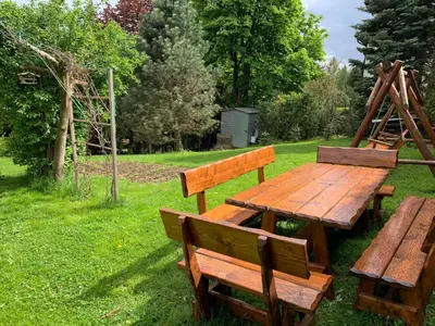 a picnic table and benches in the grass at DOM KKK in Rabka