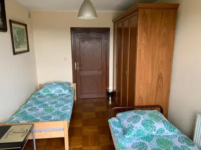 a room with two beds and a wooden door at DOM KKK in Rabka