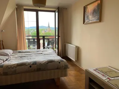 a bedroom with a bed and a large window at DOM KKK in Rabka