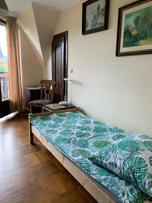 a bedroom with a bed with a green and white comforter at DOM KKK in Rabka