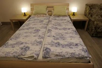 a bed with a blue and white blanket on it at Stare Miasto Zyblikiewicza in Kraków
