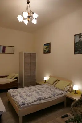 a bedroom with a bed and a chandelier at Stare Miasto Zyblikiewicza in Kraków