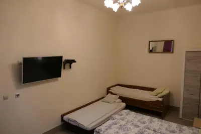 a room with two beds and a flat screen tv on the wall at Stare Miasto Zyblikiewicza in Kraków