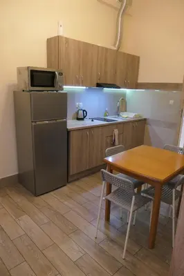 a kitchen with a table and a microwave and a refrigerator at Stare Miasto Zyblikiewicza in Kraków