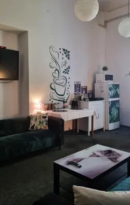 a living room with a couch and a coffee table at Green Cat Rooms in Kraków