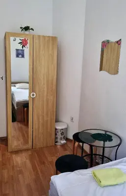 a room with a door and a table and a mirror at Green Cat Rooms in Kraków