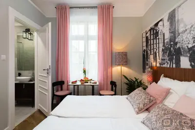 a bedroom with a bed and a sink and a window at Starowislna 77 in Kraków
