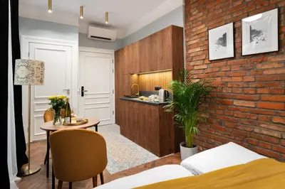 a bedroom with a brick wall and a table and a kitchen at Starowislna 77 in Kraków