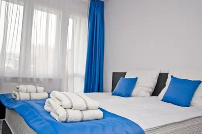 a bedroom with two beds with blue and white pillows at Park Apartamenty Chrzanów in Chrzanów