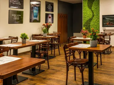 a dining room with wooden tables and chairs at Park Apartamenty Chrzanów in Chrzanów