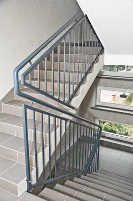 a staircase with a metal railing in a building at Park Apartamenty Chrzanów in Chrzanów