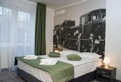 a bedroom with a large bed with a train mural on the wall at Park Apartamenty Chrzanów in Chrzanów
