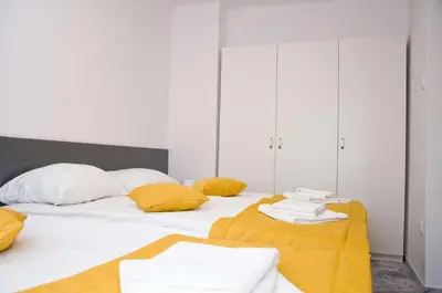 a bedroom with two beds with yellow pillows at Park Apartamenty Chrzanów in Chrzanów
