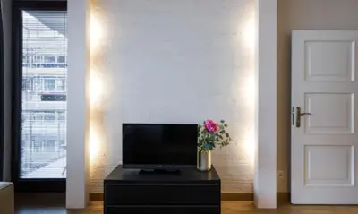 a living room with a television and a vase of flowers at Royal Parkside in Kraków