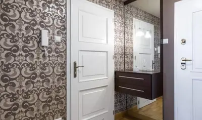 a bathroom with a white door and a sink at Royal Parkside in Kraków