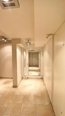 an empty room with a hallway with a tile floor at Royal Parkside in Kraków
