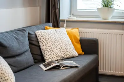 a couch with a pillow and two books on it at Perfect place to stay in Kraków City Center in Kraków