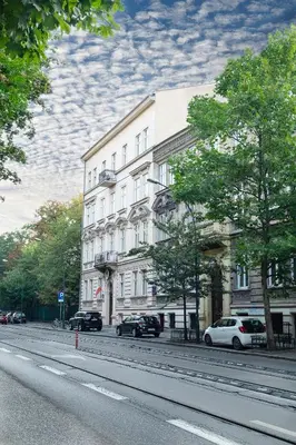 a large white building on the side of a street at Hotel Maximum in Kraków