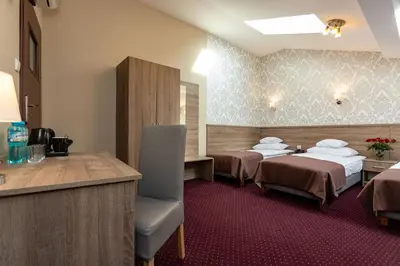 a hotel room with two beds and a bar at Hotel Maximum in Kraków