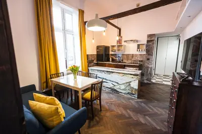 a living room with a table and a kitchen at Stylish Apartment in Krakow Old Town in Kraków