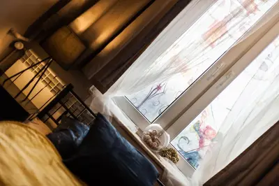 a bedroom with a window and a bed with blue pillows at Stylish Apartment in Krakow Old Town in Kraków