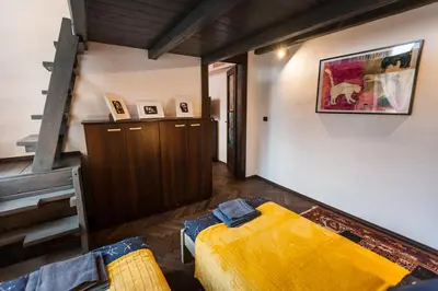 a living room with a yellow bed and a staircase at Stylish Apartment in Krakow Old Town in Kraków