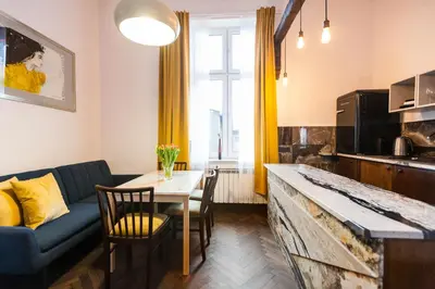 a living room with a blue couch and a table at Stylish Apartment in Krakow Old Town in Kraków