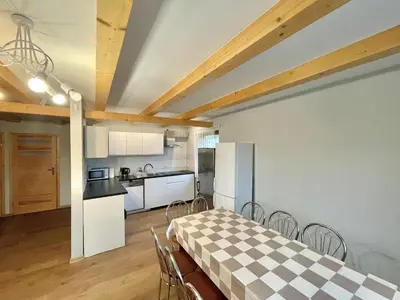 a kitchen and dining room with a table and chairs at Domek przy Gościńcu in Golczowice