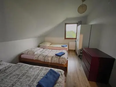 a bedroom with three beds and a dresser and a window at Domek przy Gościńcu in Golczowice