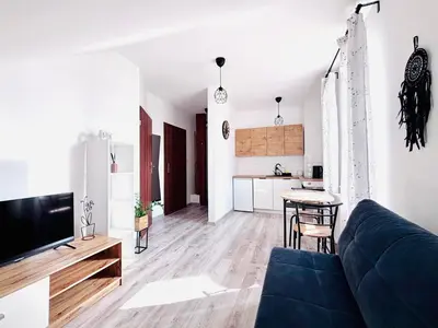 a living room with a blue couch and a kitchen at Apartament Salton in Bochnia