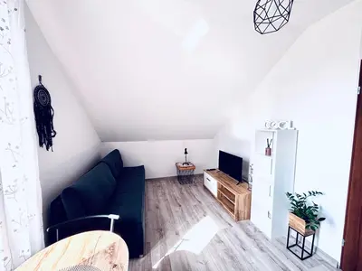 a living room with a blue couch and a tv at Apartament Salton in Bochnia