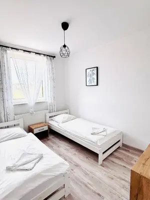 a bedroom with two beds and a window at Apartament Salton in Bochnia