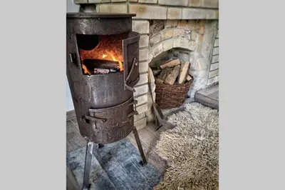 an old wood stove with a fire in it at Lawenda i Bluszcz in Jankowice
