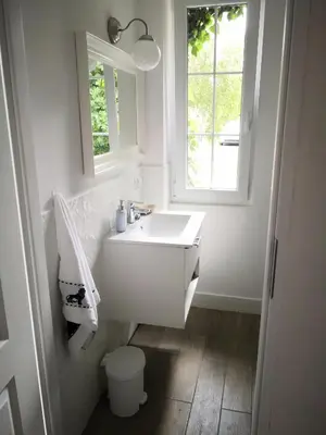 a white bathroom with a sink and a window at Lawenda i Bluszcz in Jankowice