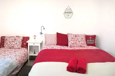 a bedroom with a bed with red and white pillows at Lawenda i Bluszcz in Jankowice