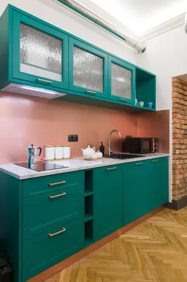 a kitchen with green cabinets and a sink at LUXURY Apartment at the Main Square in Kraków