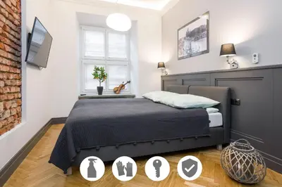 a bedroom with a bed and a brick wall at LUXURY Apartment at the Main Square in Kraków